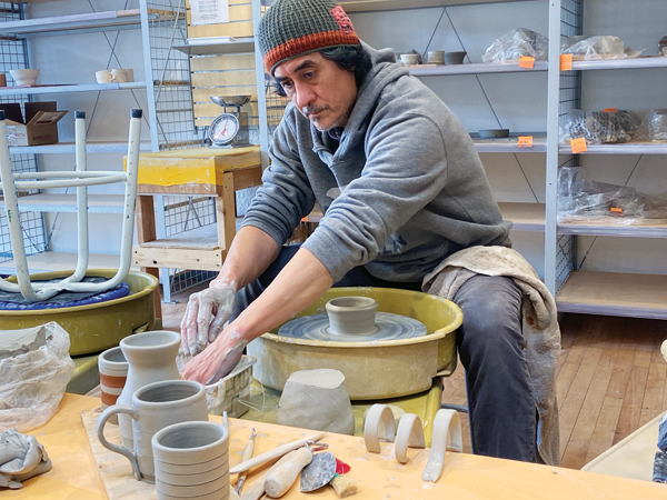 6 Studio assistant Rene Gutierrez working on cups. 
