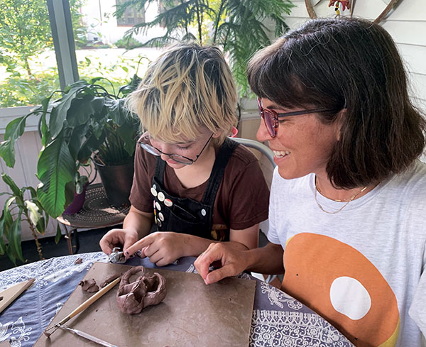 7 A young artist, named Doa, constructing an organic form on his porch with a Pinch Pot Craft Takeout kit. All photos: Erin Furimsky and Tyler Lotz. 