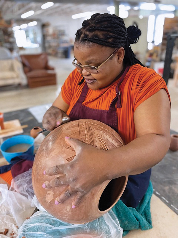2 Jabu Nala burnishing a pot. Once dry, the pot will be placed with up to 20 other pieces in an open-air firing that reaches between 800–1000°F (427–538°C). 