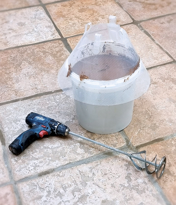 1 Pour your reclaim into a 5-gallon bucket, attach a plaster-mixing paddle to a cordless drill, and place a plastic “cone of shame” dog cone over the bucket. 