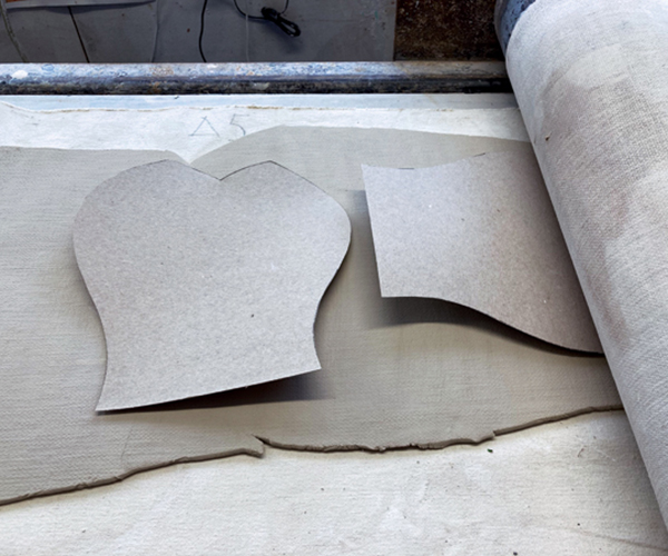 1 Lay cardboard templates on a rolled slab. Roll again to stick the cardboard to the clay.