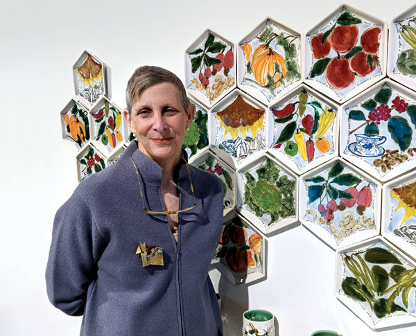 Kate Lydon pictured with Anna Metcalfe’s Pop Up Pollinator Picnic, porcelain, glaze, transfer prints, 2016–2021. Photo: Mandy Wilson.