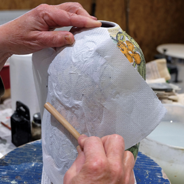 15 Place a paper towel over the painted design, and rub it with the handle of a bamboo brush.