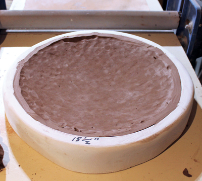 3 Cut away the excess clay around the rim with a wire tool. 