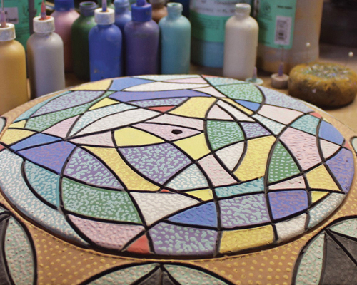 13 After applying multiple coats of underglaze, add a layer of dots in other colors over the painted sections.