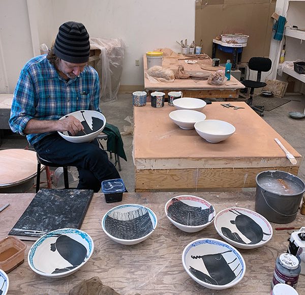 3 Kurt Anderson decorating bowls in the Voulkos studio at the Archie Bray Foundation for the Ceramic Arts. Photo: Amanda Wilkey.