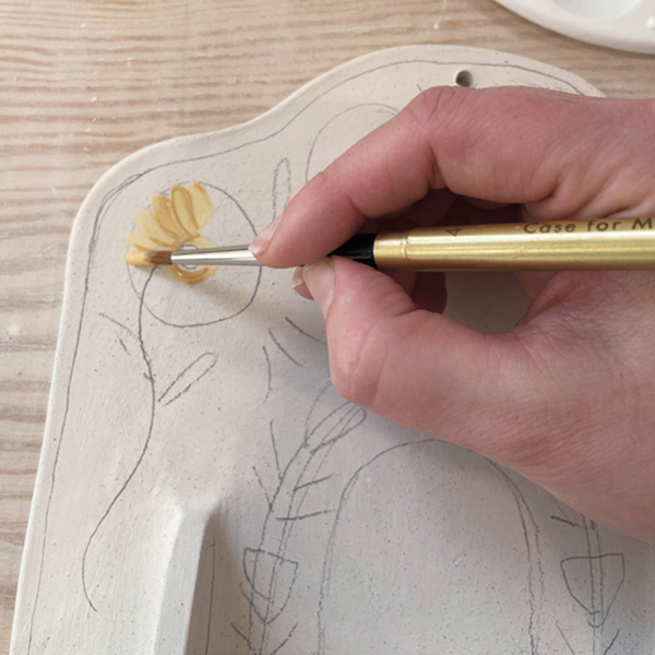 13 Pick underglaze colors and start to paint the design using your sketch as a guide.