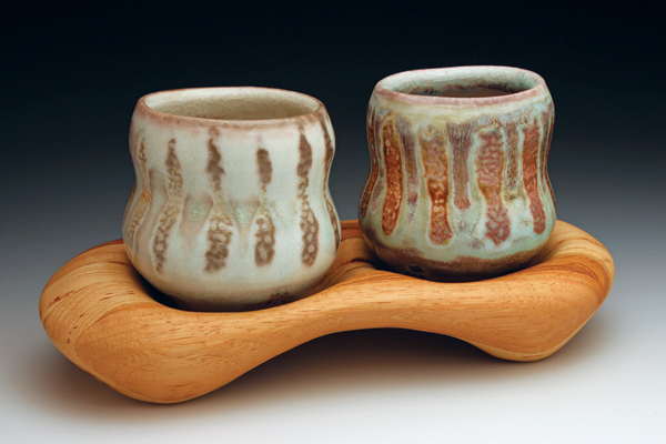 18 Cups with tray, 10 in. (25 cm) in length, porcelain, Honey Celadon and Oxidation Celadon glazes, carved wood tray. All pieces fired to cone 10 reduction in a soda/wood kiln.