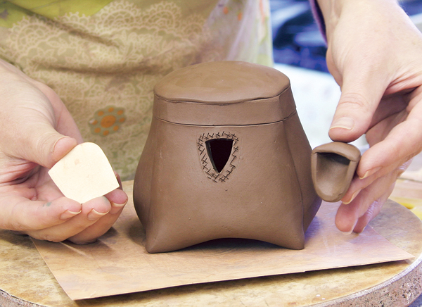 9 Cut away clay from the pot just inside the traced line of the spout, so that there is enough surface area to attach the spout.