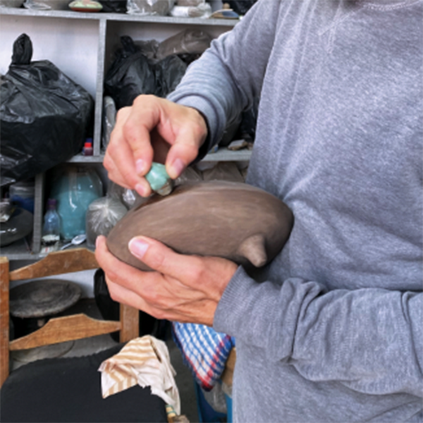 E Burnishing the surface of a churumbela armadillo with a polished piece of iron pyrite. 