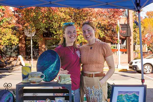 1 Madeleine Boucher (left) and MK Noonan (right) at the MadKat Studios booth during an art fair in Elizabeth, Pennsylvania. 