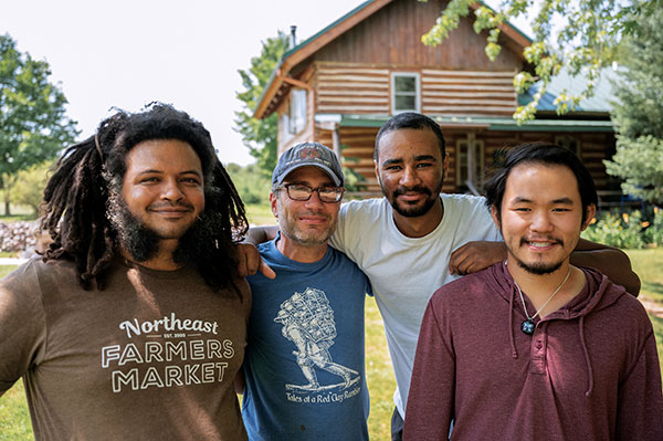 4 Left to right: Dominique Venzant, Simon Levin, Mike Tavares, and Brian Chen gathered around an anagama firing in Wisconsin, 2021. Photo: Bryce Risley. 
