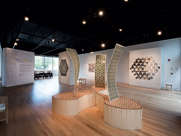 1 Exhibition view of “Making Place Matter,” with works by artists Kukuli Velarde (background, far left), Molly Hatch (background, center and right), and Ibrahim Said (foreground). 