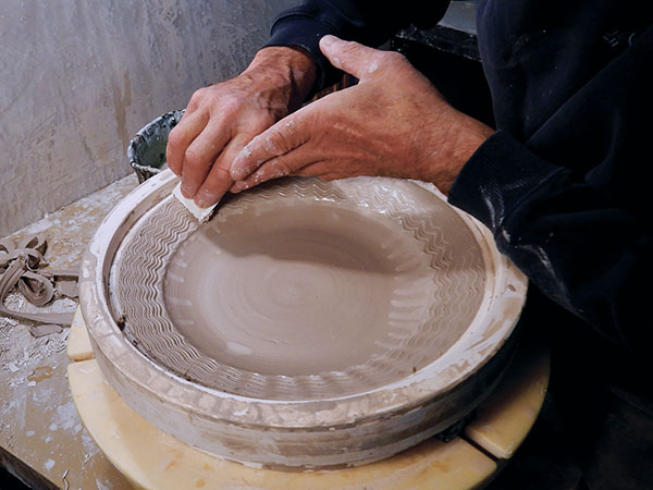 22 Creating a combing pattern on the rim of the fish plate.