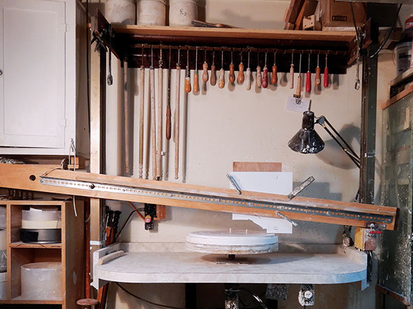 12 Plaster-turning wheel with a styrene profile template clamped to the pivoting jigger arm. 