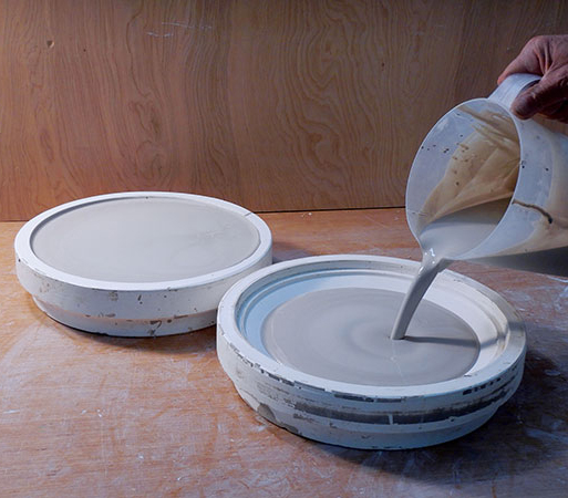 17 Filling the finished mold with white stoneware slip. 