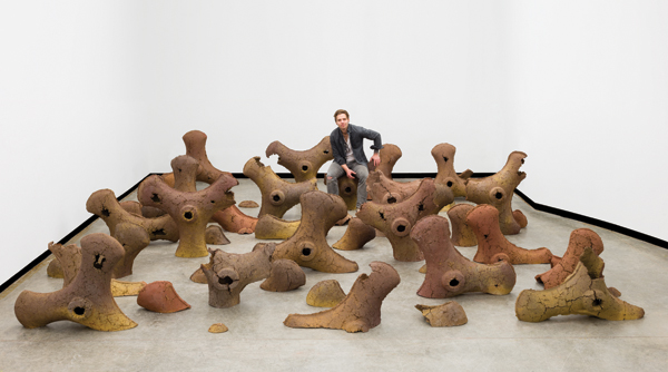 1 Peter Smith pictured with pieces in his Tiller Blade installation. The pieces are press-molded clay and cement, fired to cone 6 in reduction.