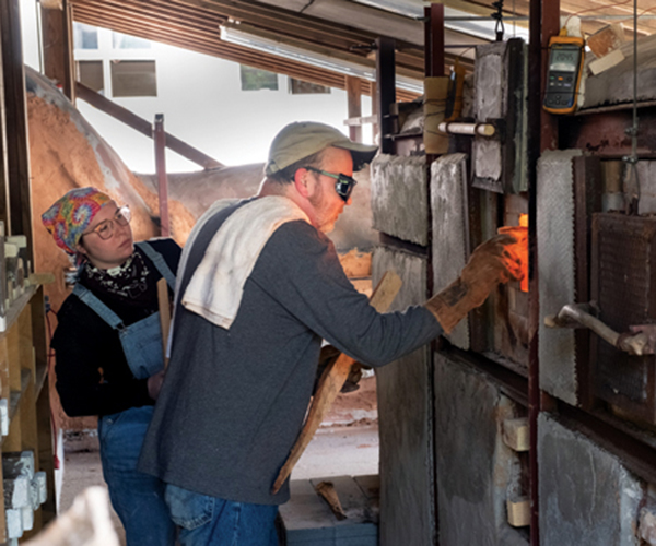 15 Stoking the small wood kiln while at a summer workshop at Penland School of Craft. Photo: Robin Dreyer. 
