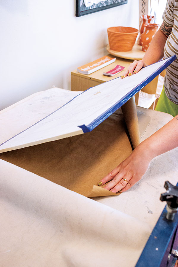 2 Covering a freshly rolled and smoothed slab with parchment paper and a flat drywall board. 