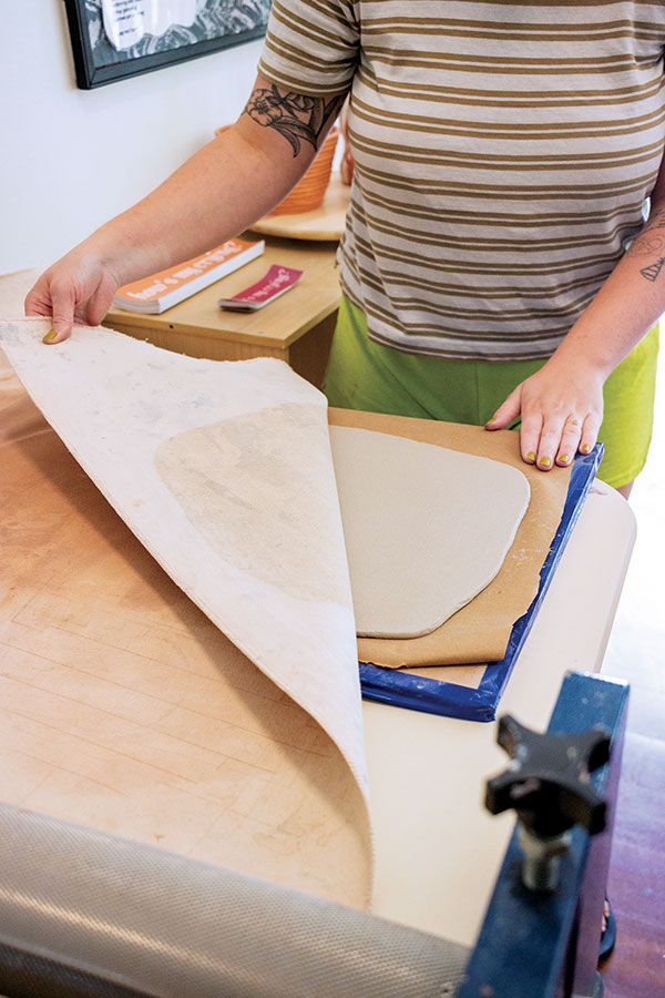 3 Flip the drywall boards with the slab in between so that the parchment paper is on the bottom of your clay slab. Carefully peel back the canvas and smooth the newly exposed slab surface.