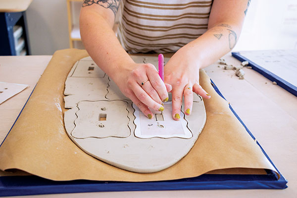 4 Tracing the scaled-up switch cover templates onto a leather-hard clay slab. 