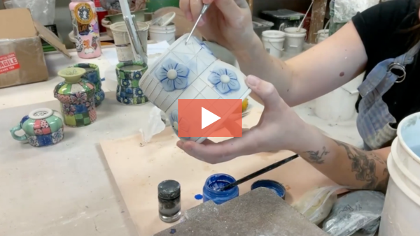 Image of Be Rose scratching a design into a clay mug