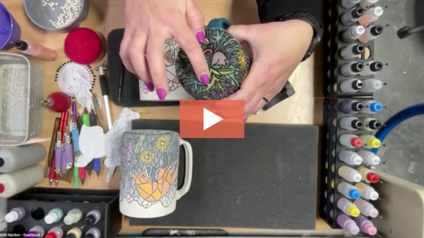 Image of Beth Harden pointing out carved details on a handmade mug