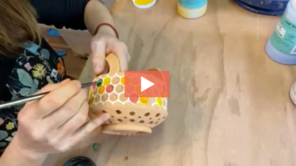 Amy Brummond painting underglaze on a bisque fired berry bowl