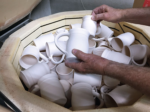 1 Mugs tumbled stacked on top of tumblers.