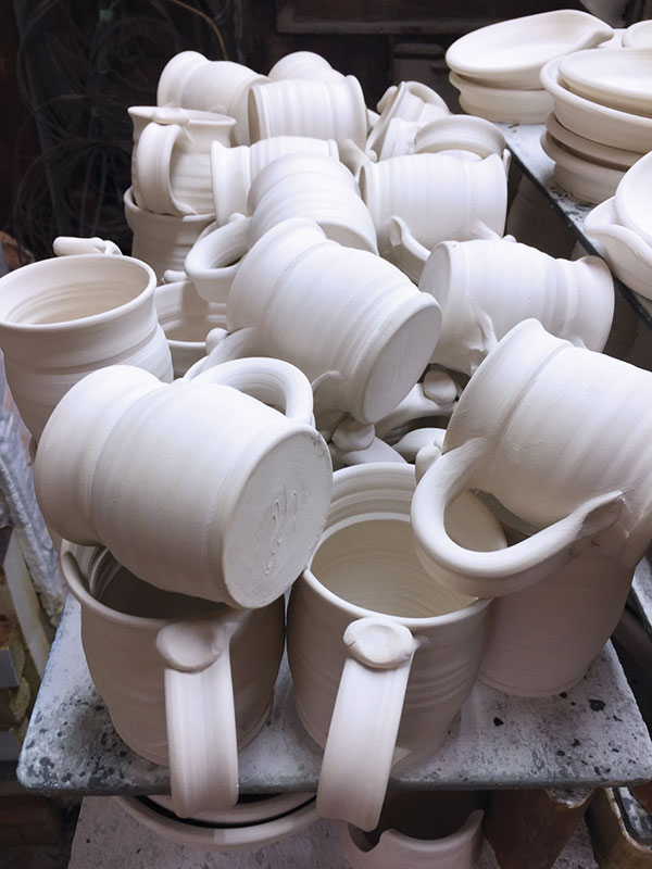 11 A car-kiln bisque load with a top layer of tumble-stacked mugs on top of upright mugs.