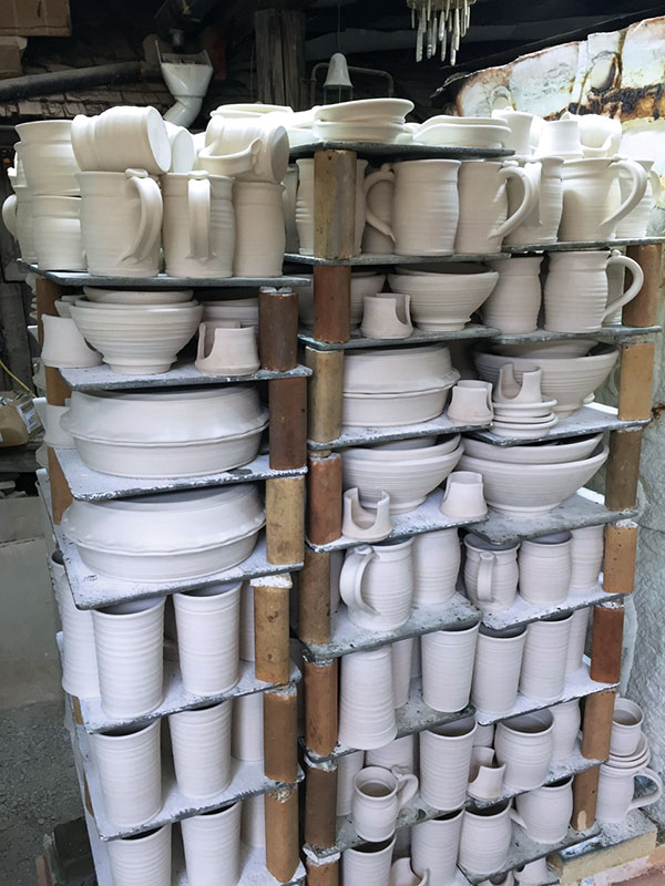 12 Car-kiln bisque load with a few top layers of tumble-stacked pots as well as layers of pots placed rim to rim (pie plates left and center) and layers with pots nested inside one another (bowls and small forms on the right).