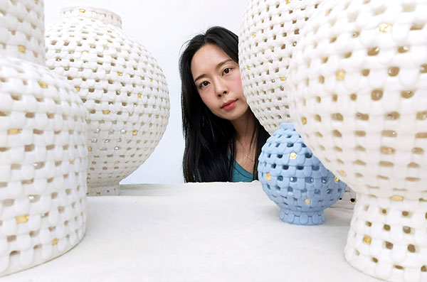 2 YoonJee Kwak in her studio in Helena, Montana, with sculptural vessels, 2020.