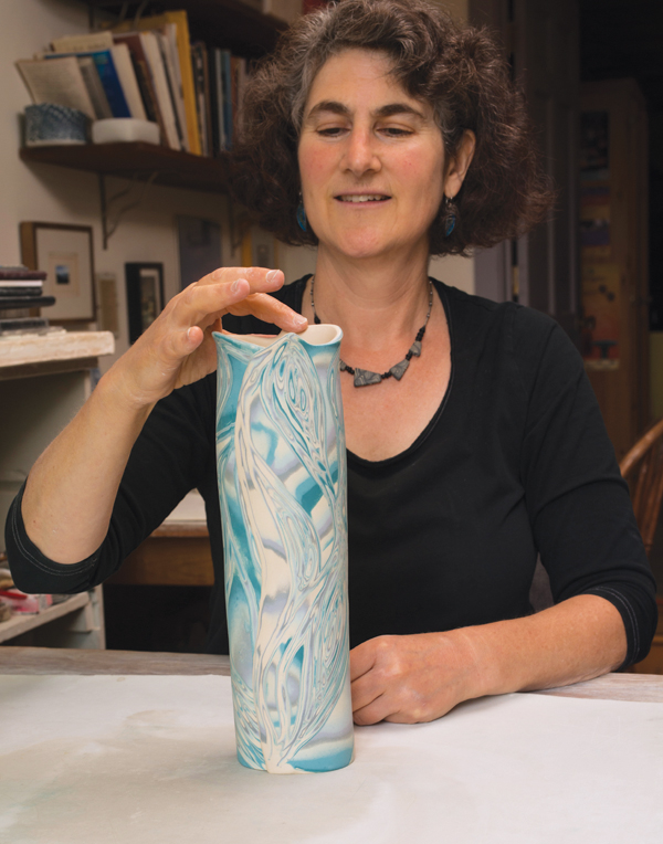 Naomi Lindenfeld working on Curves and Waves vase in her studio.