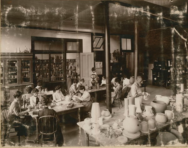 2 Newcomb Pottery designers working in a pottery decorating class conducted by Mary Sheerer. Newcomb Pottery Building. Washington Avenue Campus, ca. 1905. Newcomb Art School Scrapbook, University Archives, Tulane University.