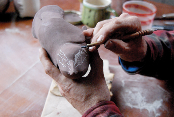 3 Carving the sgraffito patterns through black slip to reveal the white clay body underneath. Photos: Penny Guisinger.
