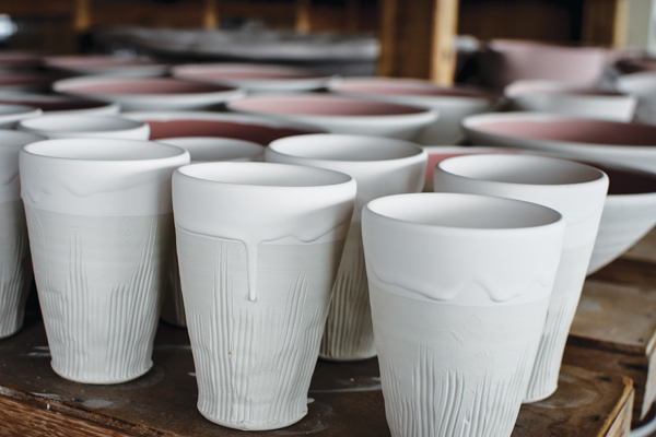 3 Raw glazed cups and bowls on ware boards in the studio, awaiting once firing in the wood kiln.