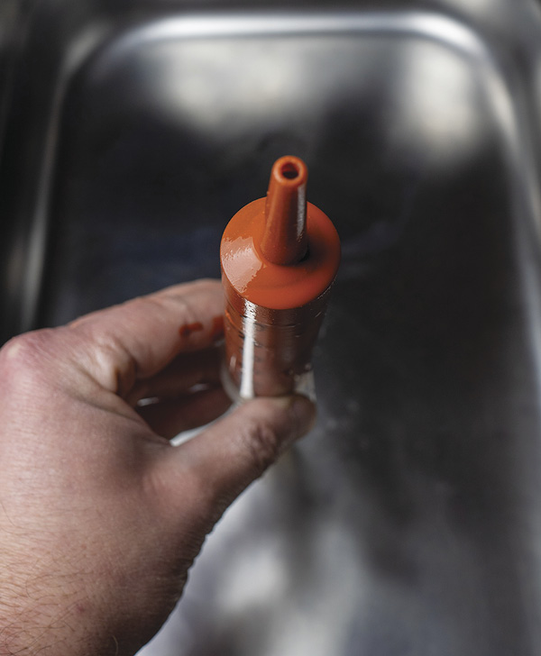 2 Place the syringe in the bucket with the plunger sitting on the bottom of the bucket and the pointy bit facing up.