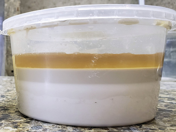 1 A glaze that has been sitting undisturbed. The solid particles have settled in layers and water has risen to the top.