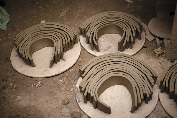 5 Clay slabs arranged on wooden pallets ready to be used for construction.