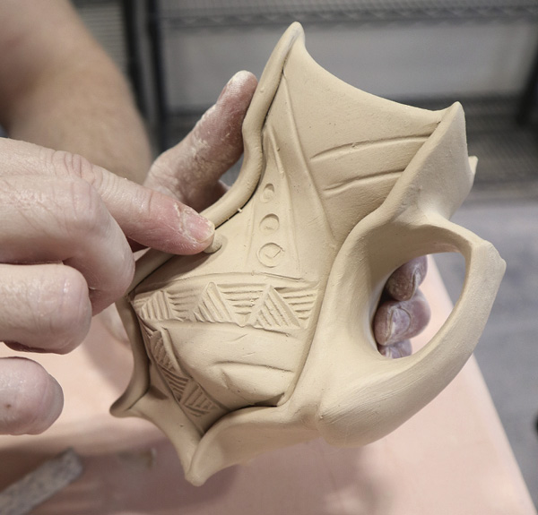 20 After applying stamped texture to the vessel, create additive interest with small balls of clay.