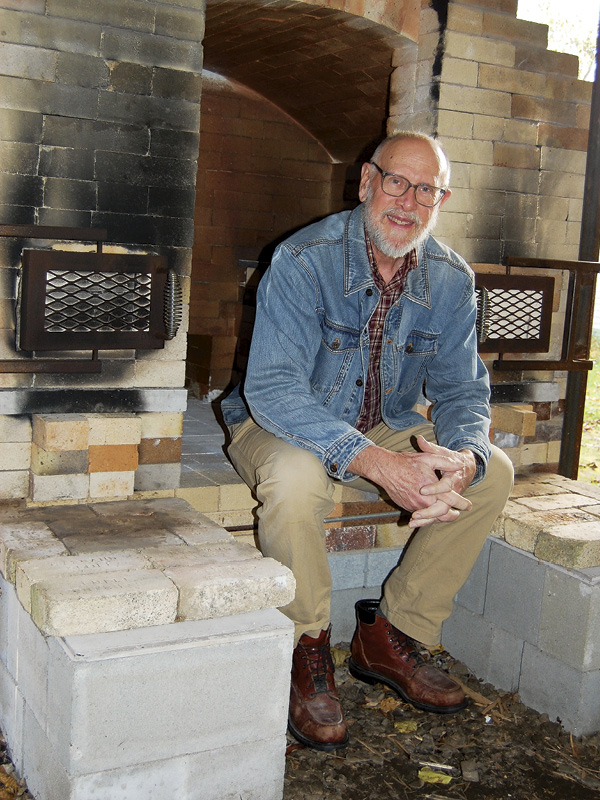 Lucien Koonce siting in front of his kiln. Photo: Karen Kennedy.