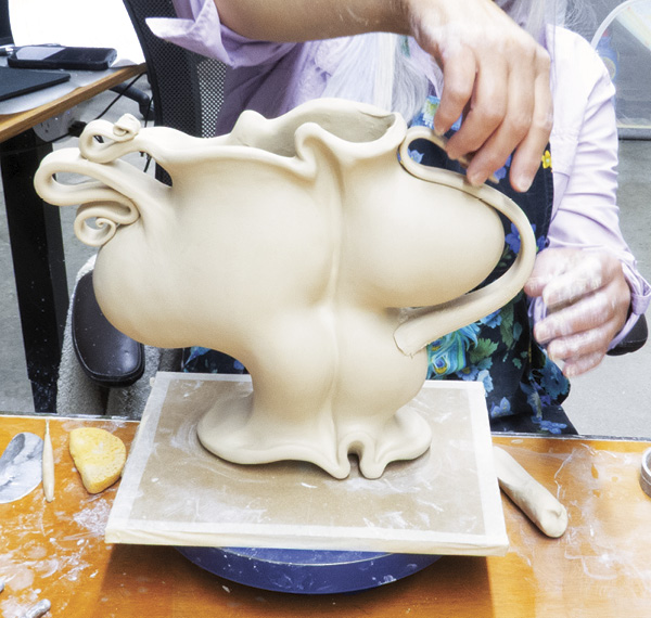 4 Add another handle so it emerges from a lower curve on the form, extending upward, creating interesting negative spaces.