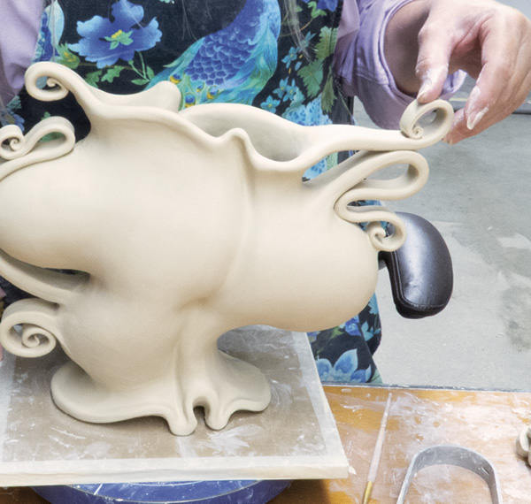 5 To avoid the handles remembering their former shape and detaching, slip and score where they actually touch the body. This curlicue sticks out into space and will unroll if not secured to itself.