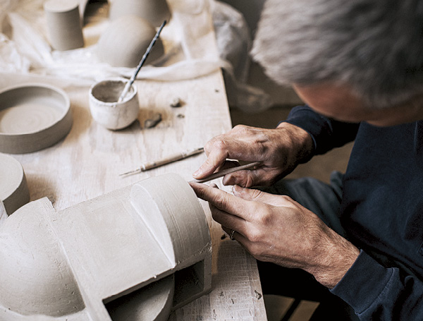 6 Wilson in the studio cutting and assembling thrown elements for a wall assemblage, 2021. Photo: Catherine Falls.