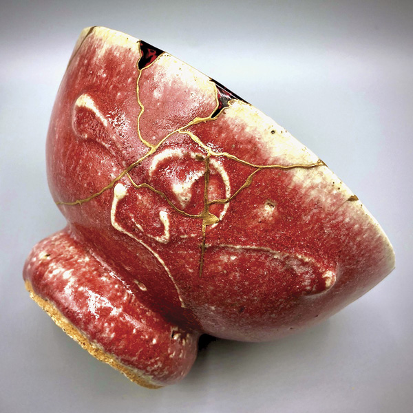 5 Imagine, 6 in. (13 cm) in diameter, cinnabar-glazed tea bowl by Kanjiro Kawai (1890—1966), repaired with resin, urushi, 231/2K gold, 2023. This piece shows the addition of a marbling effect created with lacquer and pigment applied at the lip.