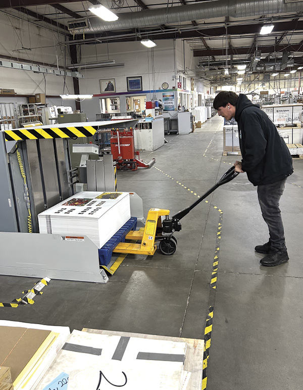 5 Stacked sheets of printed exhibition catalog pages at AZ Litho being transferred by forklift to the next phase of production.
