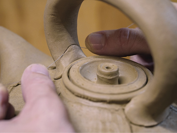 15 Attach the handle close to the lid opening.