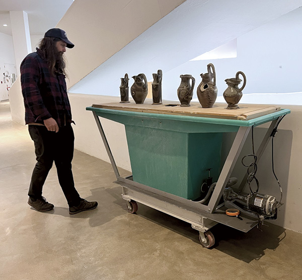 7 University of Iowa ceramics studio technician Benj Upchurch observing the work of Casey Beck, graduate student at the University of Nebraska in residence at the University of Iowa.