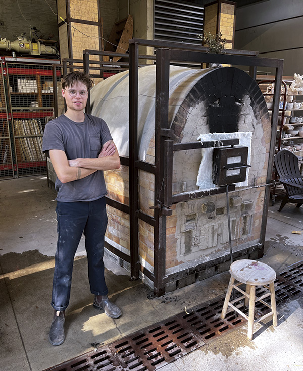 15 Casey Beck, graduate student at the University of Nebraska, with completed bricked-up wood kiln at the University of Iowa.