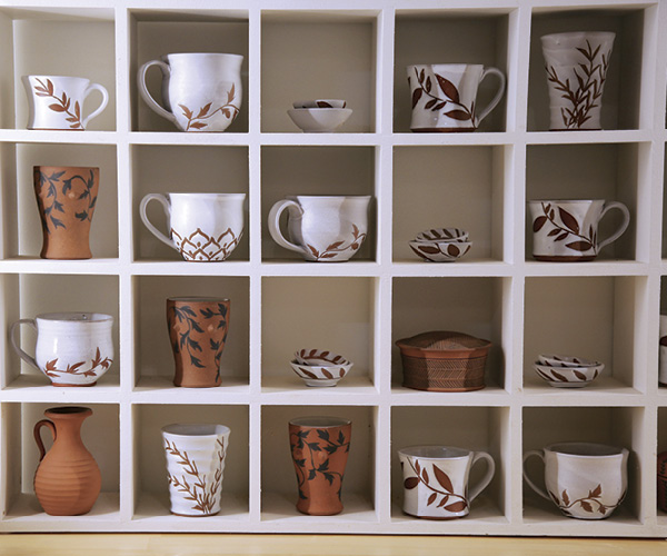 Kyla Strid's finished mugs in cube shelving.